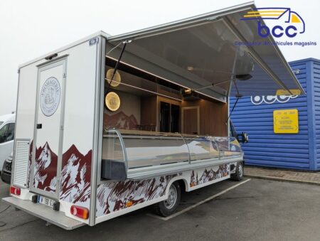 Camion magasin pour crémier-fromager, avec vitrine réfrigérée et décoration montagne, présenté devant les locaux de BCC