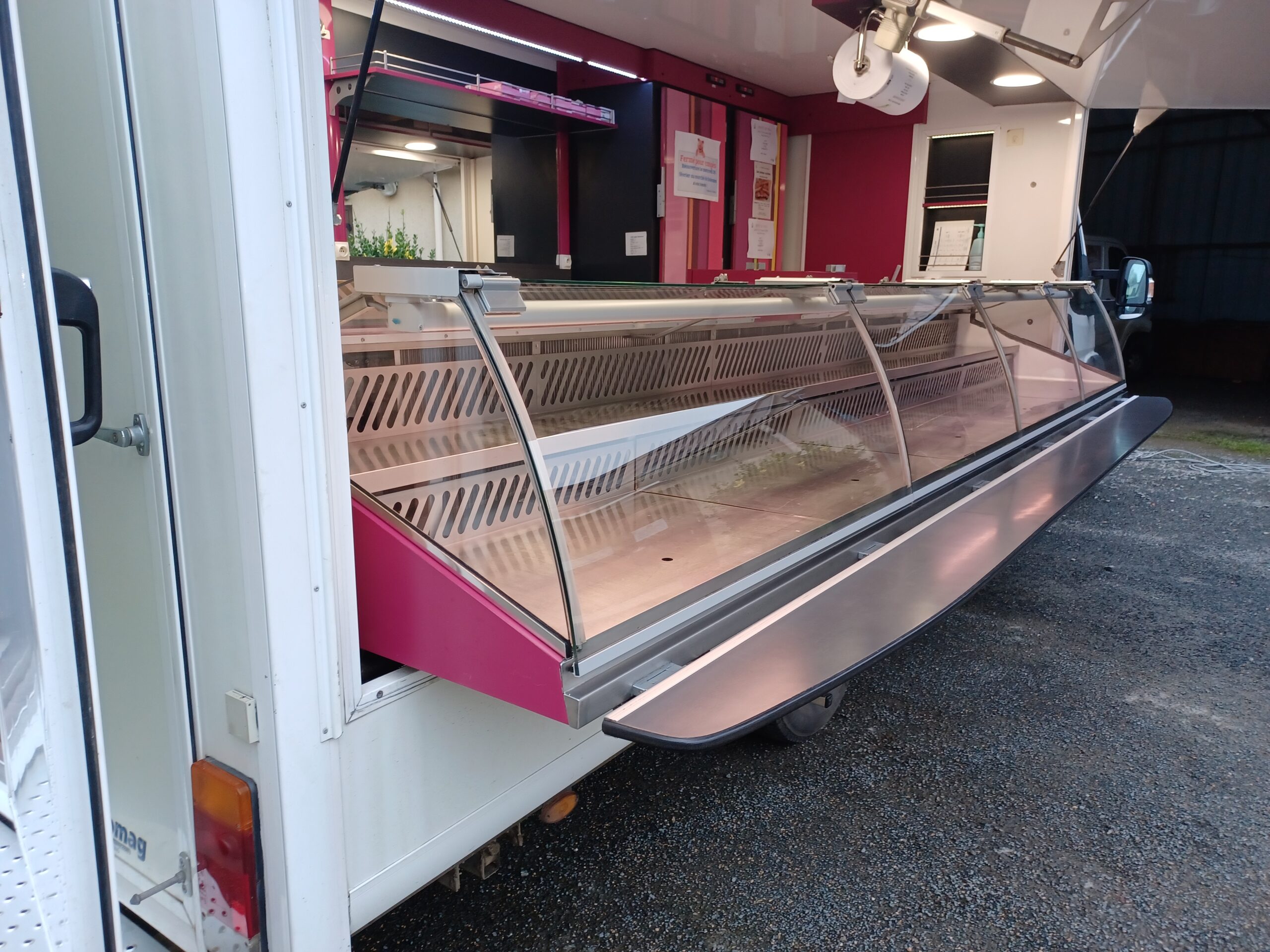 Vitrine extérieure ouverte d’un camion boucherie de marché avec protection plexiglas