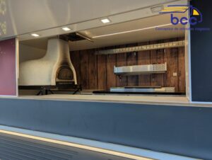 Comptoir de service et four à bois intégrés dans le foodtruck pizza